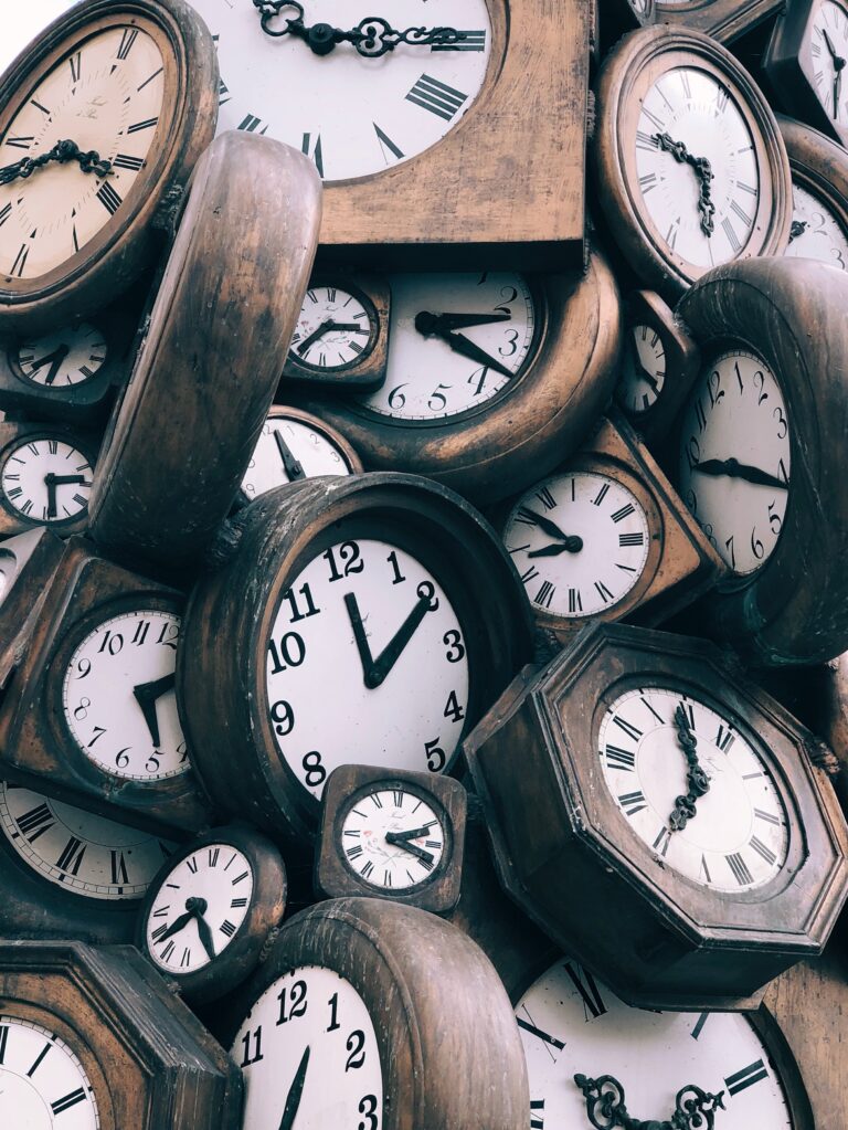 A pile of clocks showing different times