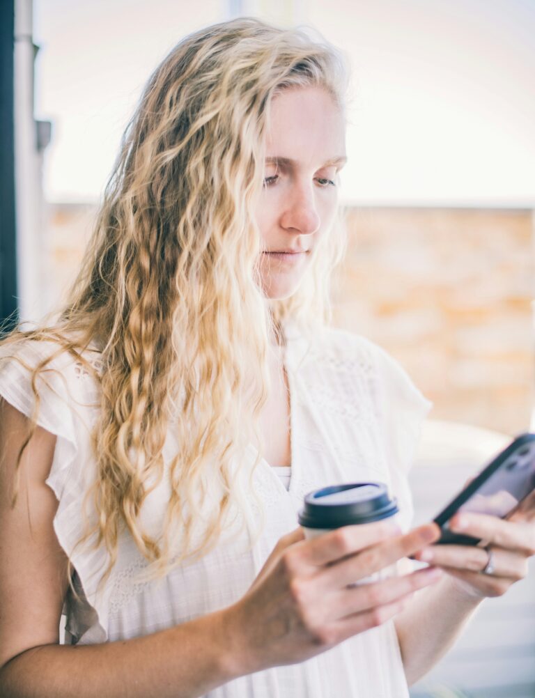 blonde woman looking at phone to plan time