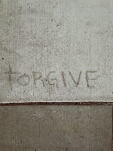 The word "forgive" written on pavement