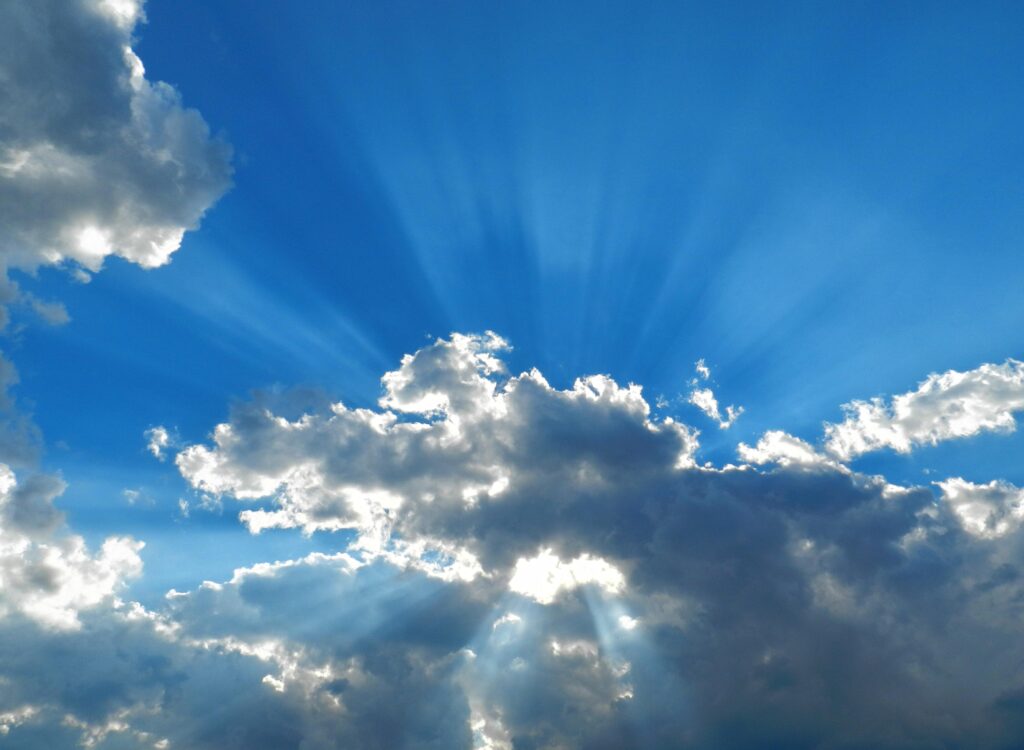 Sunshine breaking through the clouds on a blue sunny day