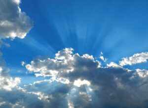 Sunshine breaking through the clouds on a blue sunny day