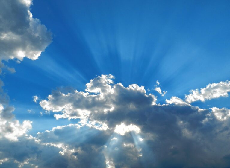 Sunshine breaking through the clouds on a blue sunny day